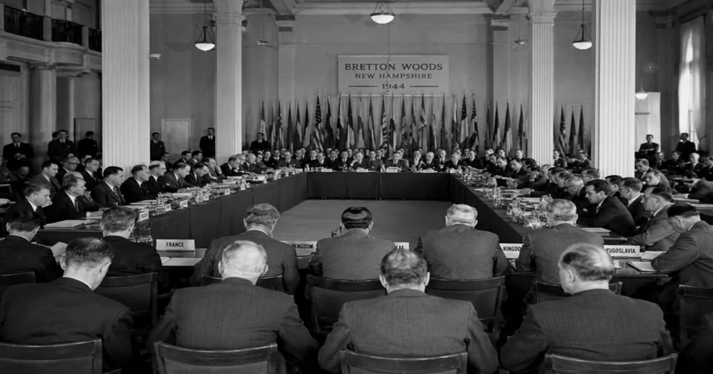 A historical black-and-white photograph of the grand conference room at bretton woods in 1944, showing international central bankers and economists gathered to debate the new global dollar-gold architecture and its impact on the history of gold.